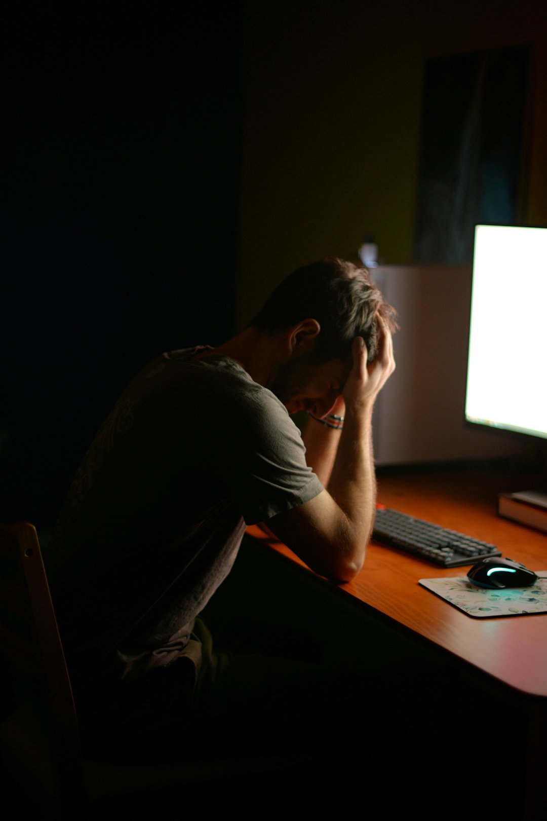 a-man-sitting-at-a-desk-in-front-of-a-computer.jpg a man sitting at a desk in front of a computer